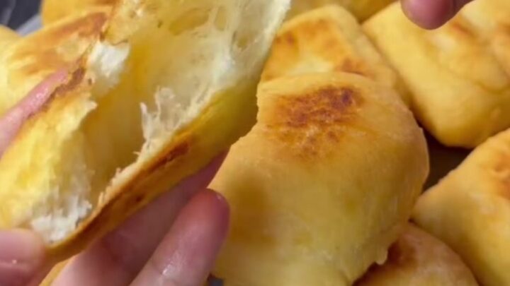 Golden fried pishmaniye bread on a rustic plate, steam rising from a torn piece