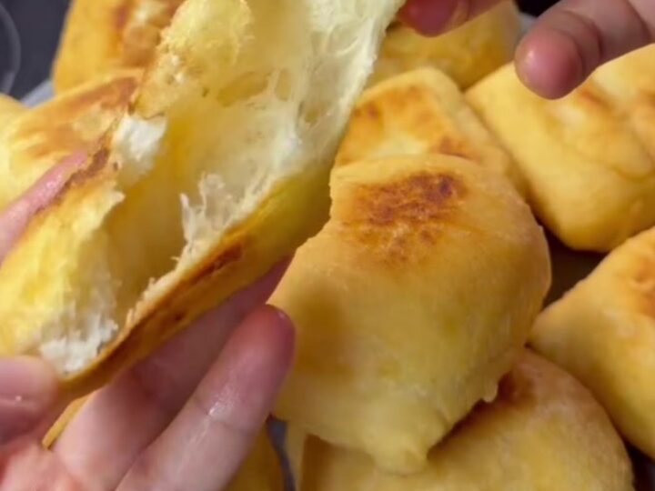 Golden fried pishmaniye bread on a rustic plate, steam rising from a torn piece