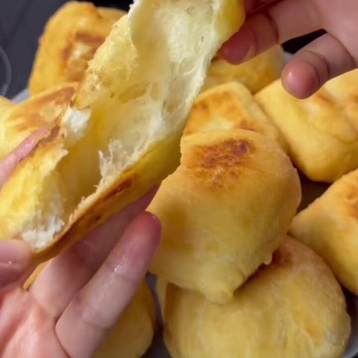 Golden fried pishmaniye bread on a rustic plate, steam rising from a torn piece