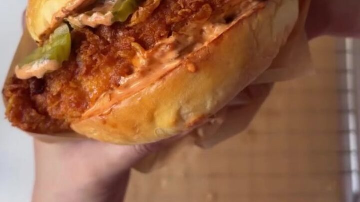 Crispy fried chicken sandwich on a toasted brioche bun with garlic herb mayo, pickles, and lettuce