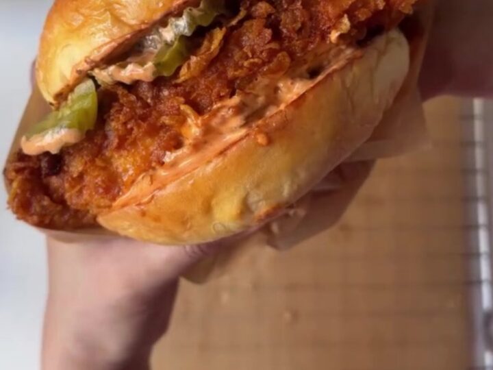 Crispy fried chicken sandwich on a toasted brioche bun with garlic herb mayo, pickles, and lettuce