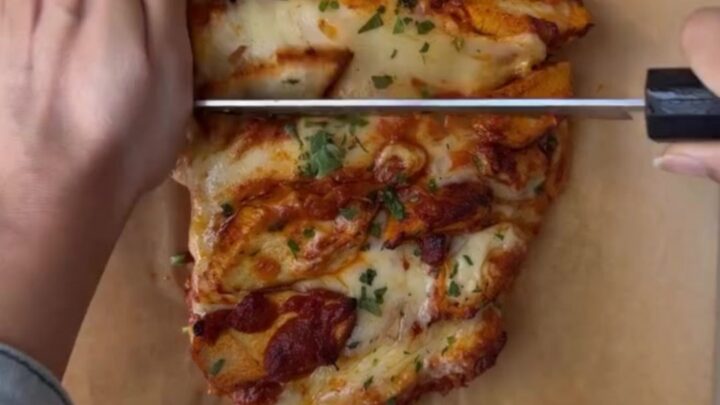 Loaded baguette with bubbling mozzarella and butter chicken, sliced to show cheese pull