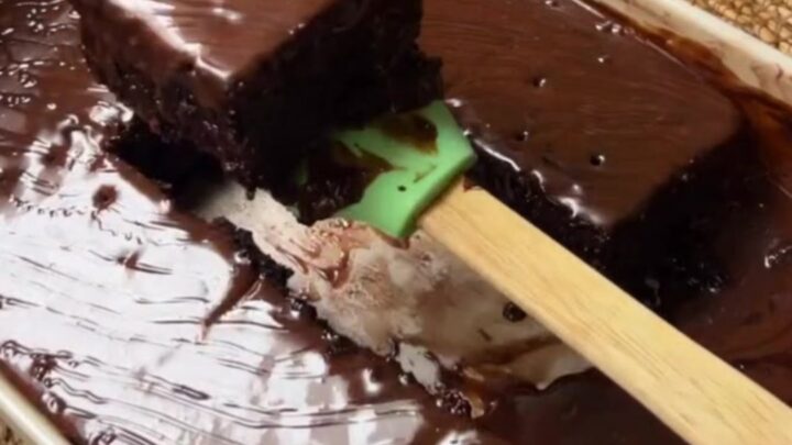 Fudgy chocolate cake squares topped with crushed pistachios and drizzled with chocolate syrup