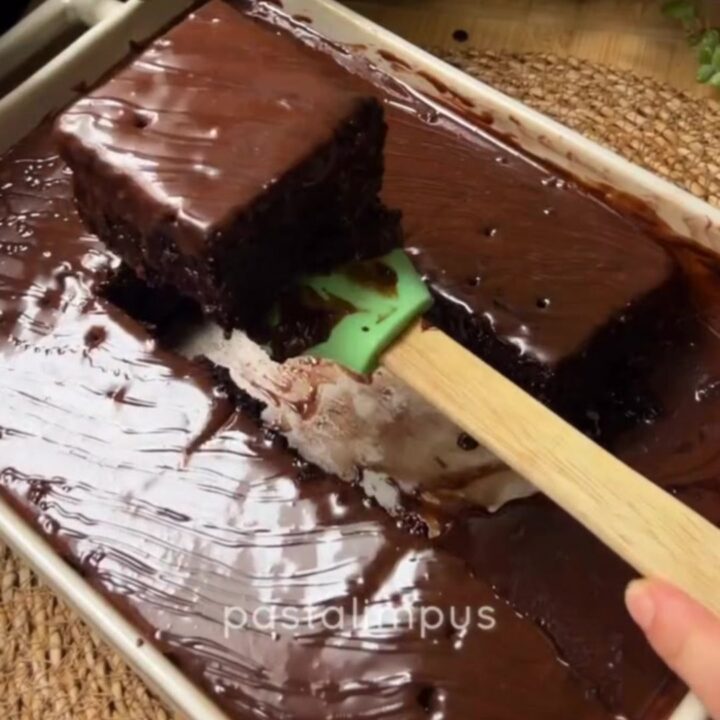 Fudgy chocolate cake squares topped with crushed pistachios and drizzled with chocolate syrup