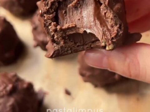 A truffle sliced in half revealing a molten Nutella center, with a crunchy hazelnut shell and chewy biscuit ring.