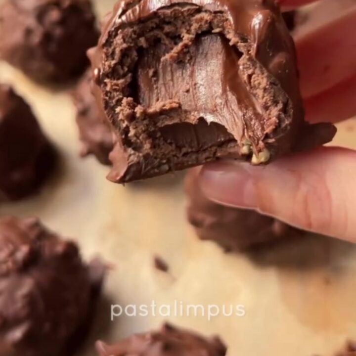 A truffle sliced in half revealing a molten Nutella center, with a crunchy hazelnut shell and chewy biscuit ring.