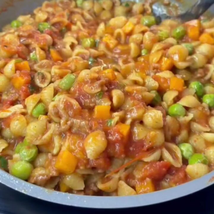 Spoonful of cheesy meatball shell pasta with melted mozzarella and parsley