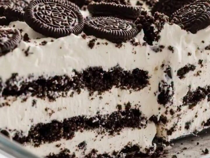 A decadent slice of Oreo icebox cake showing clear layers of dark chocolate cookies and white whipped cream.