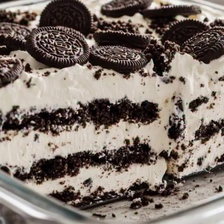 A decadent slice of Oreo icebox cake showing clear layers of dark chocolate cookies and white whipped cream.