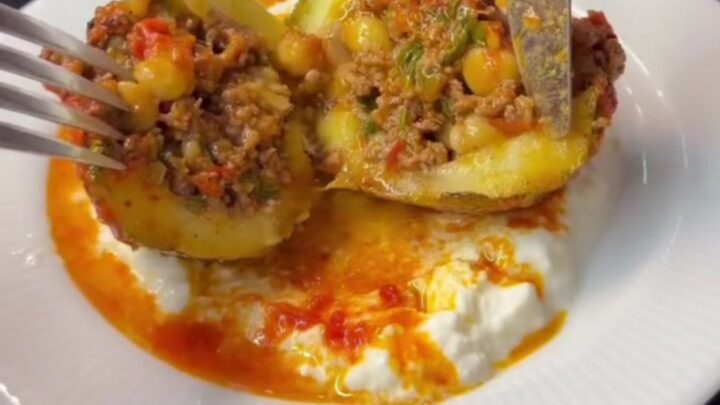 Tender stuffed round zucchini on a serving plate, cut open to reveal spiced beef and chickpeas inside