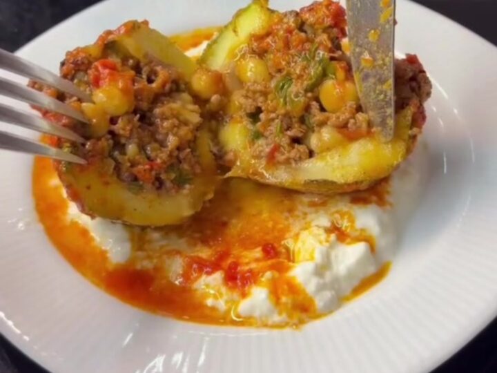 Tender stuffed round zucchini on a serving plate, cut open to reveal spiced beef and chickpeas inside