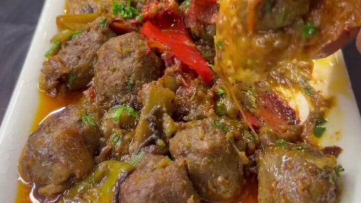 Cheesy meatball and eggplant skillet with stretchy melted cheese being lifted by a spatula