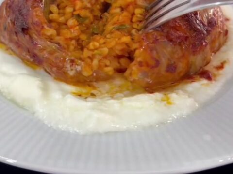 Caramelized cabbage bundles in a baking dish with tomato broth