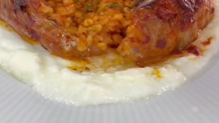 Caramelized cabbage bundles in a baking dish with tomato broth
