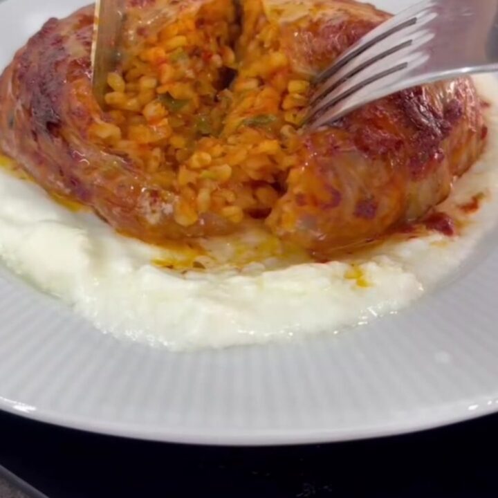 Caramelized cabbage bundles in a baking dish with tomato broth