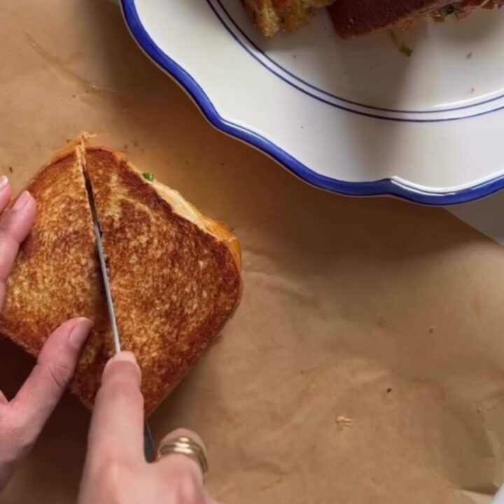 Crispy golden sandwich sliced diagonally, showing creamy chicken filling with melted cheese and vegetables
