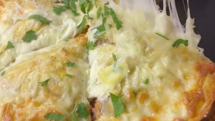 A golden-brown crispy chicken and cheese wrap pie cut into wedges, with melted cheese pulling from the slice.
