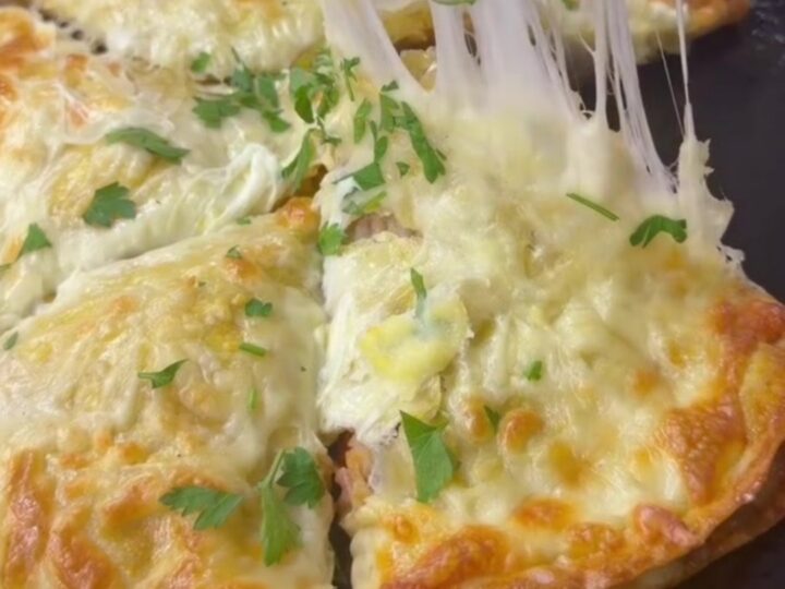 A golden-brown crispy chicken and cheese wrap pie cut into wedges, with melted cheese pulling from the slice.