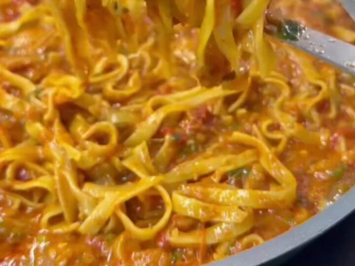 Skillet with cheesy tagliatelle and melted mozzarella, topped with parsley