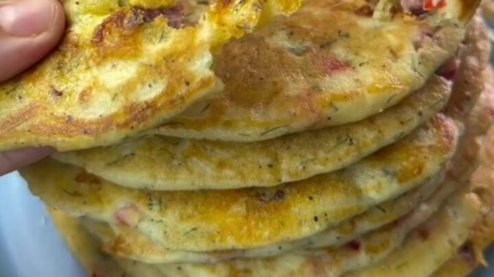 Savory pancake pizza wedges with melted cheese and sausage on a wooden board