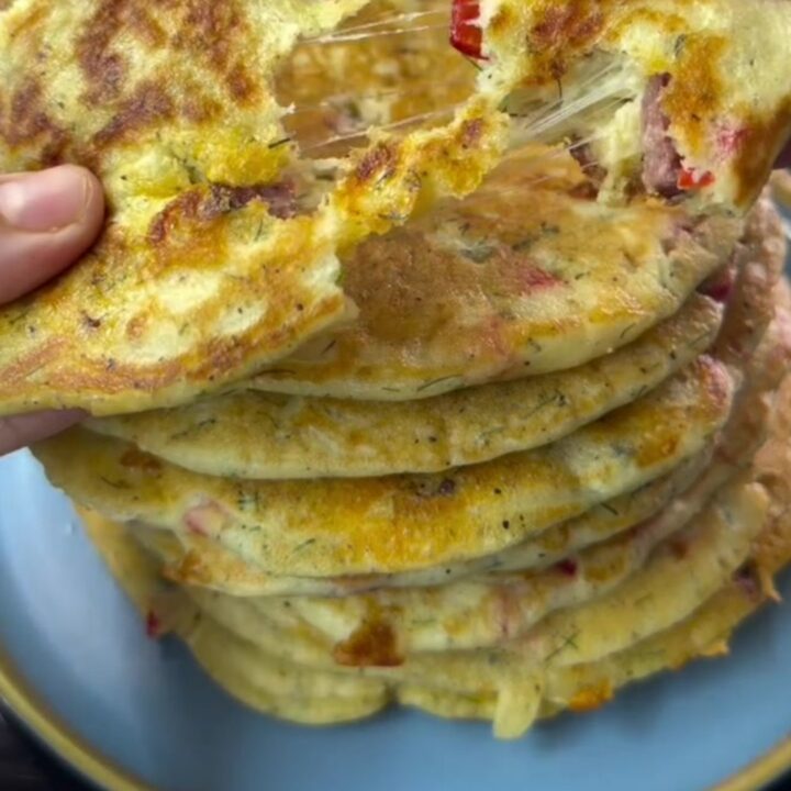 Savory pancake pizza wedges with melted cheese and sausage on a wooden board
