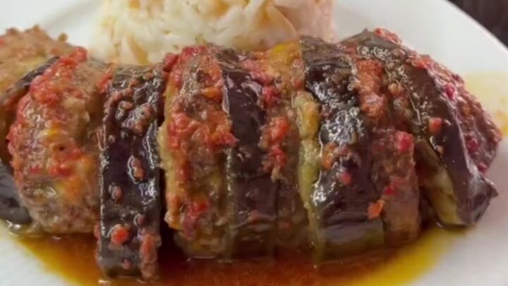 Roasted eggplant and meatballs in a baking dish with caramelized edges and tomato sauce
