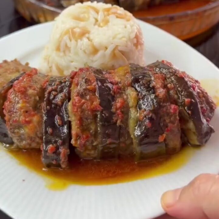 Roasted eggplant and meatballs in a baking dish with caramelized edges and tomato sauce