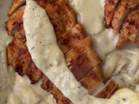 Creamy lemon garlic parmesan chicken fettuccine garnished with parsley and lemon wheels