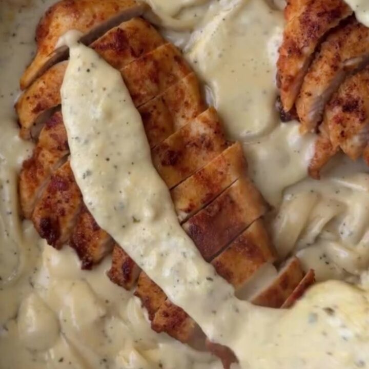 Creamy lemon garlic parmesan chicken fettuccine garnished with parsley and lemon wheels