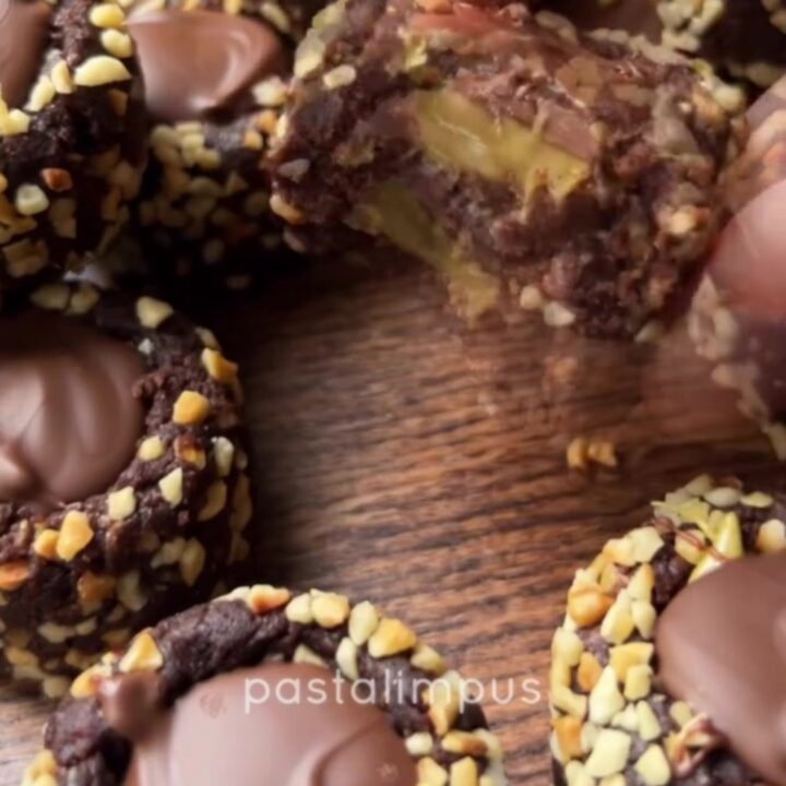 A pile of chocolate fudge bites with pistachio cream centers and chocolate drizzle