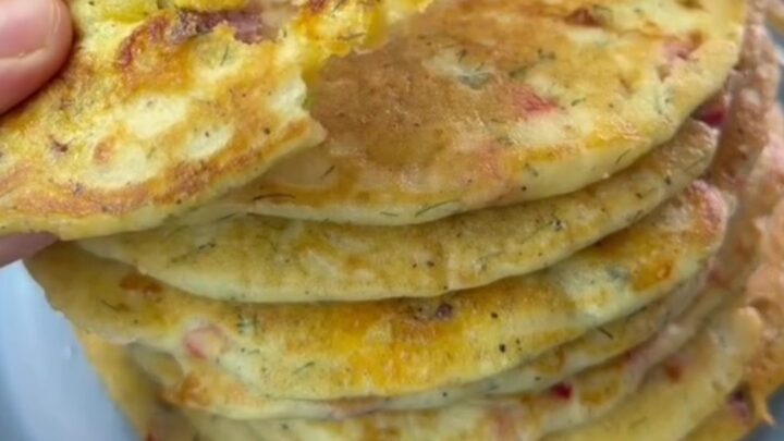 Stack of savory pancakes with feta and dill on a plate