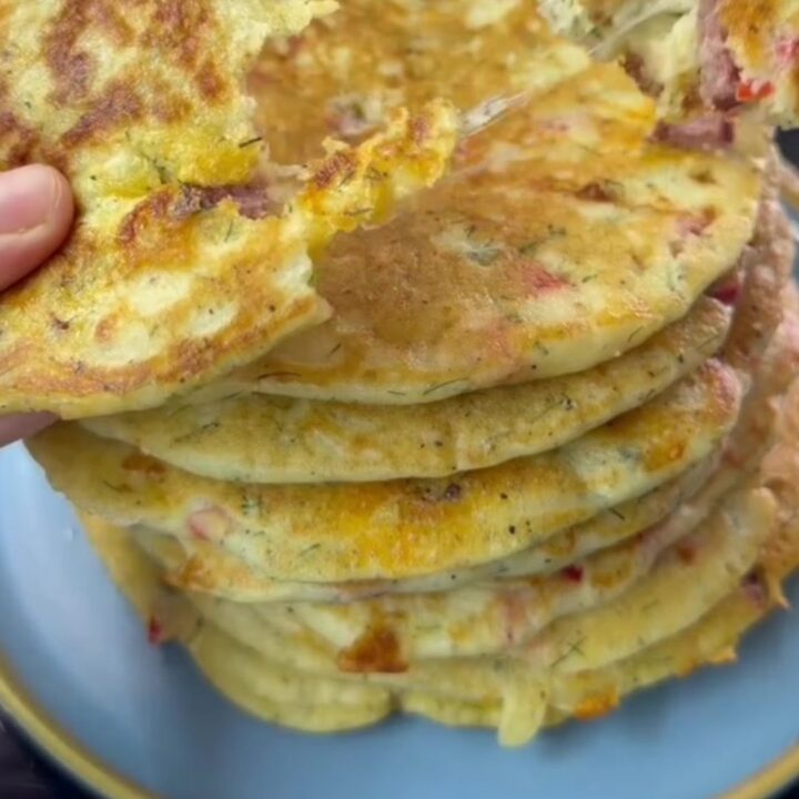 Stack of savory pancakes with feta and dill on a plate