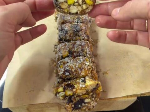 Sliced pistachio date mosaic log showing colorful nut cross-sections and coconut coating