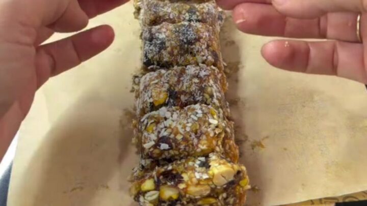 Sliced pistachio date mosaic log showing colorful nut cross-sections and coconut coating