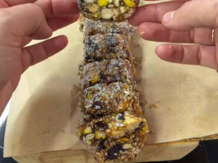 Sliced pistachio date mosaic log showing colorful nut cross-sections and coconut coating