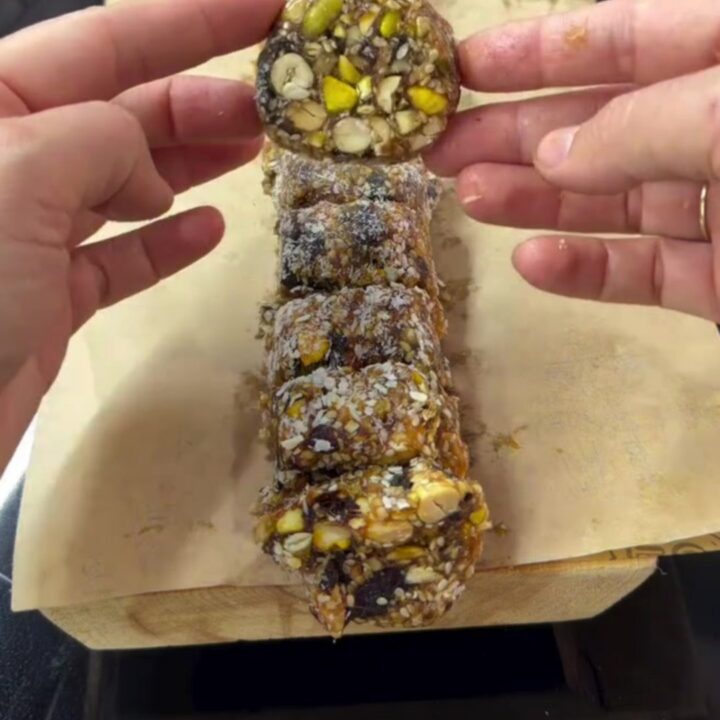Sliced pistachio date mosaic log showing colorful nut cross-sections and coconut coating