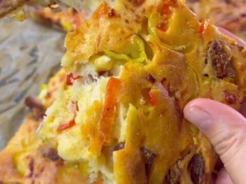 Golden sheet pan pizza cut into squares with melted cheese and pepperoni