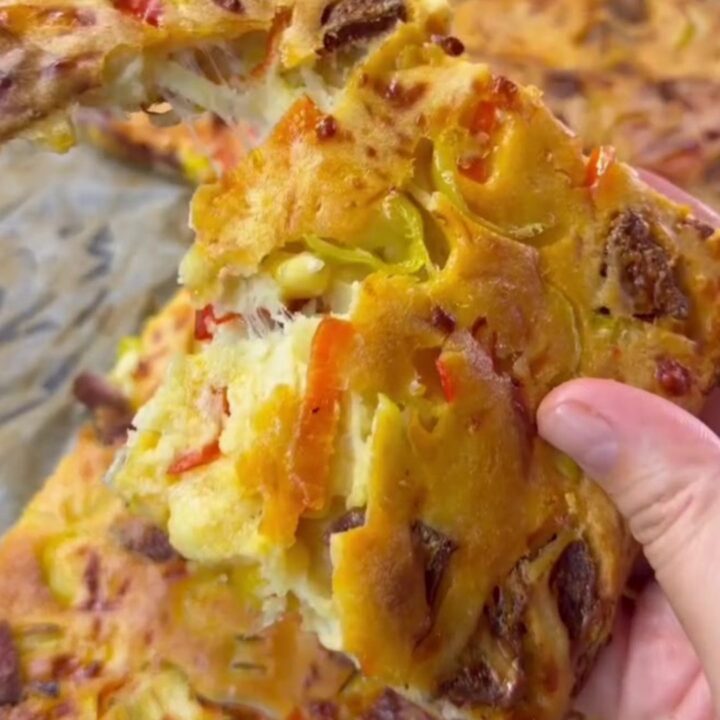 Golden sheet pan pizza cut into squares with melted cheese and pepperoni