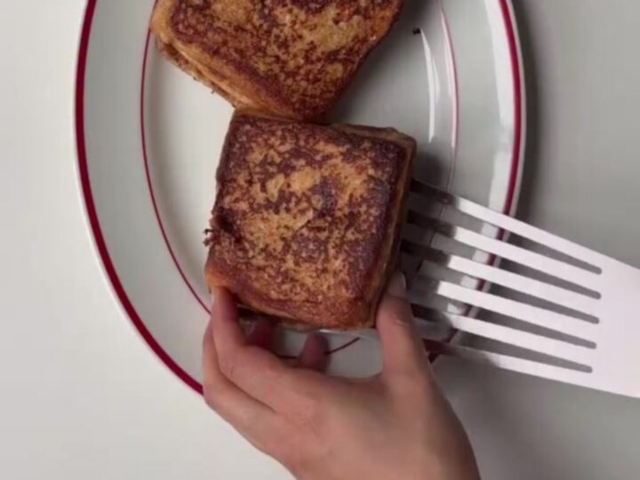Crispy cinnamon roll French toast stack drizzled with cream cheese glaze