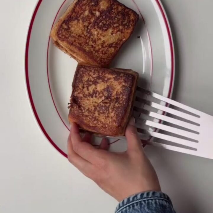 Crispy cinnamon roll French toast stack drizzled with cream cheese glaze