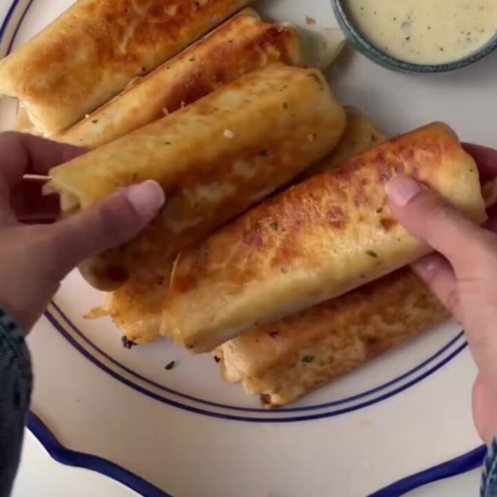 Crispy chicken Alfredo wrap sliced in half with melted mozzarella pulling