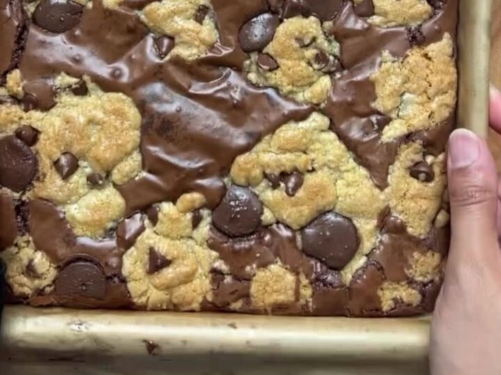 Thick brookie bar with a gooey chocolate chip cookie base and a dense brownie crown, sliced and broken in half
