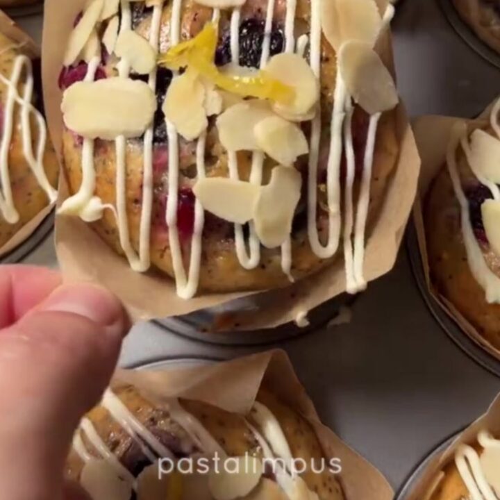 Whole lemon poppy seed berry cakes drizzled with white chocolate glaze on a wire rack