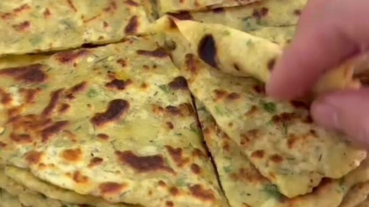 Golden brown lavaş flatbread brushed with melted butter, folded on a wooden board