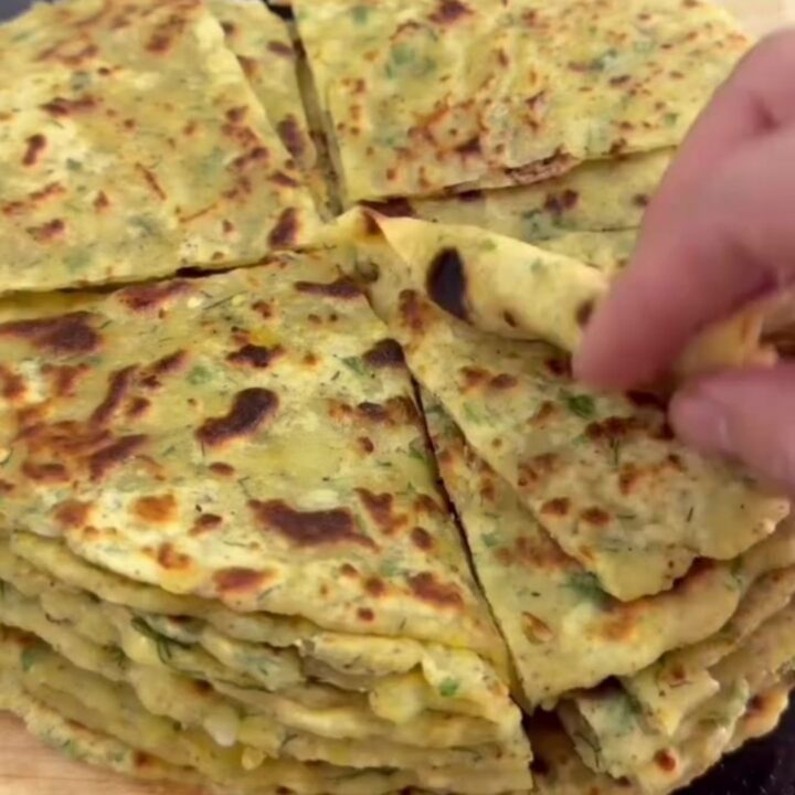 Golden brown lavaş flatbread brushed with melted butter, folded on a wooden board