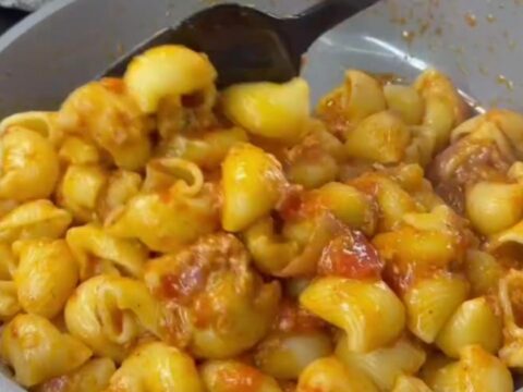 Stretchy molten cheese lifting from a spoonful of pipe rigate pasta with roasted vegetables