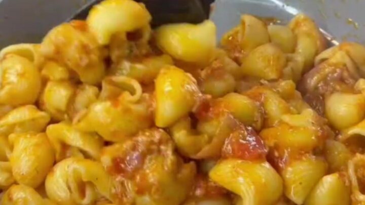 Stretchy molten cheese lifting from a spoonful of pipe rigate pasta with roasted vegetables