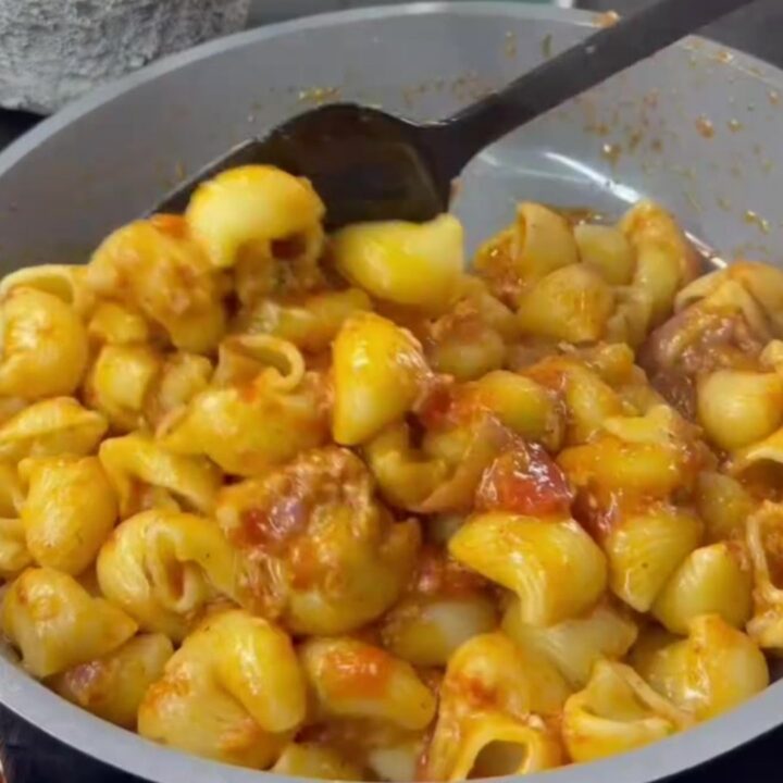 Stretchy molten cheese lifting from a spoonful of pipe rigate pasta with roasted vegetables