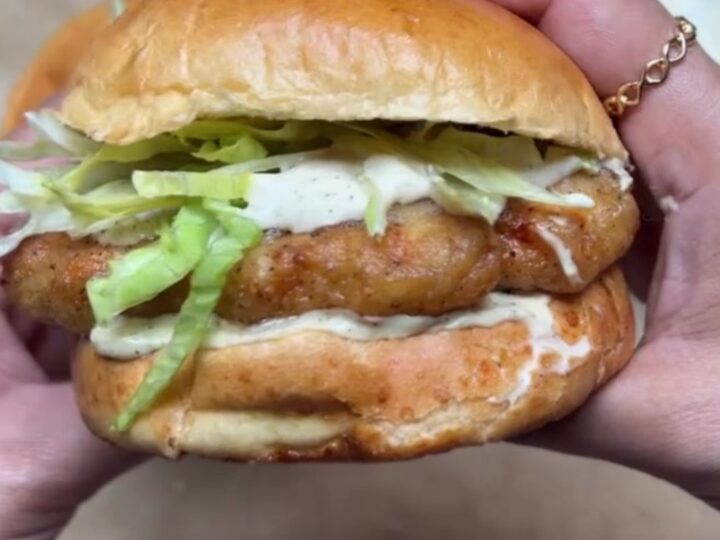 Crispy copycat McChicken sandwich on a brioche bun with lettuce and mayo sauce, taken a bite.