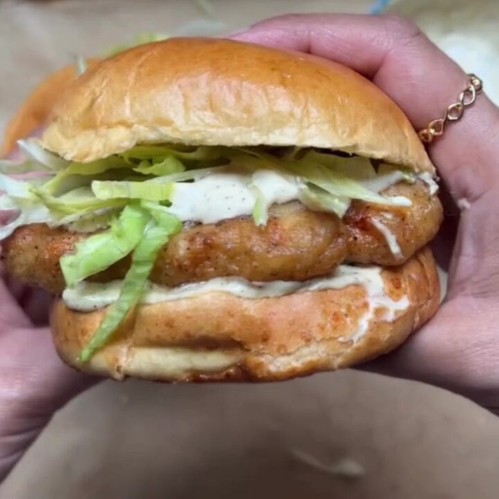 Crispy copycat McChicken sandwich on a brioche bun with lettuce and mayo sauce, taken a bite.